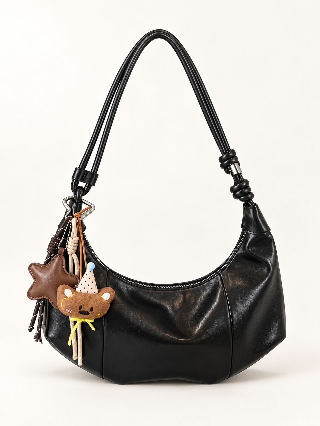 Maven Crescent Shoulder Bag in Black — studio view showing material and hardware.