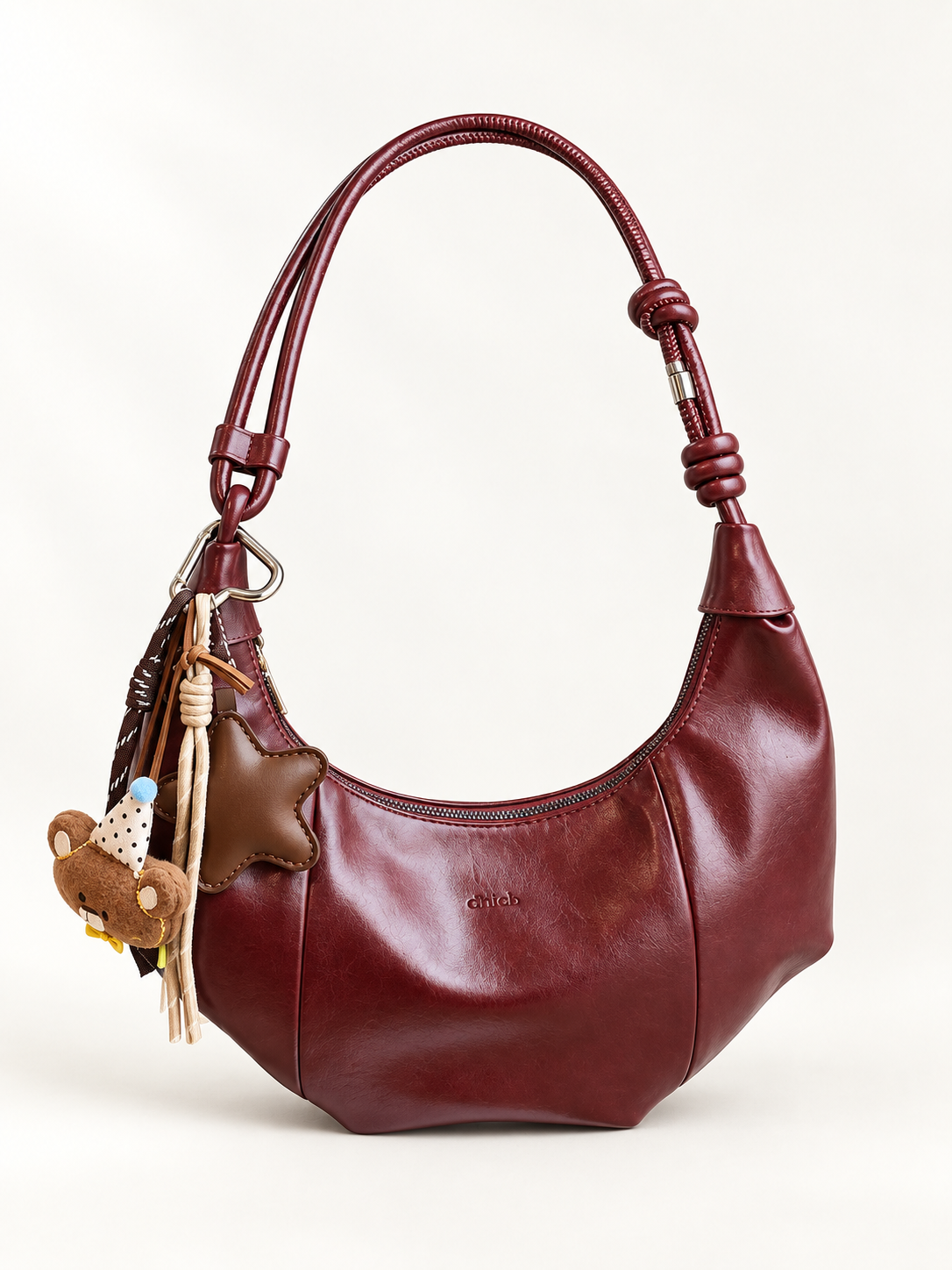 Maven Crescent Shoulder Bag in Wine Red — studio view showing material and hardware.